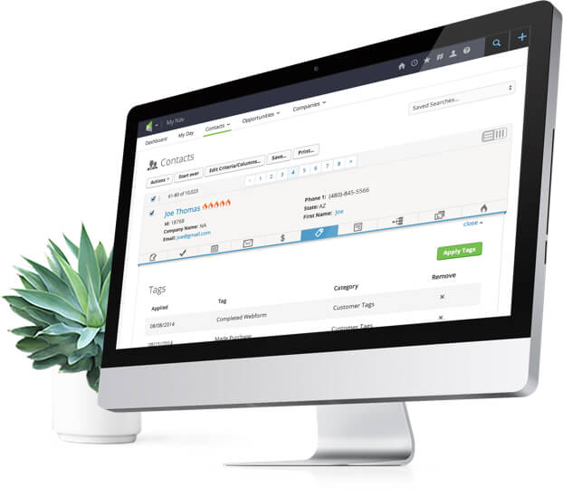 Desktop computer with Infusionsoft application and a plant